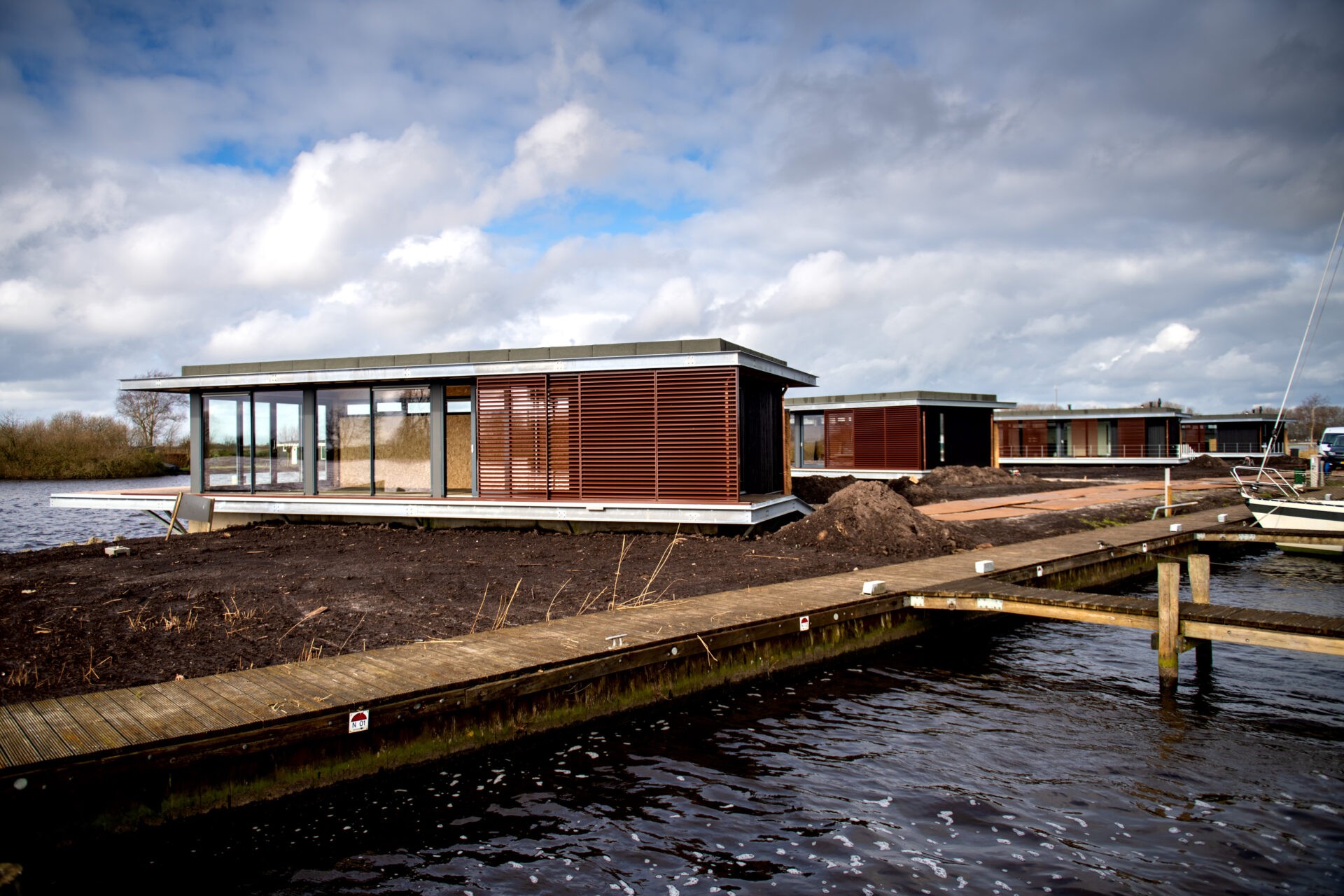 Werkzaamheden aan de afbouw van de watervilla's Natural Resort Fryslân op camping en jachthaven de Veenhoop
